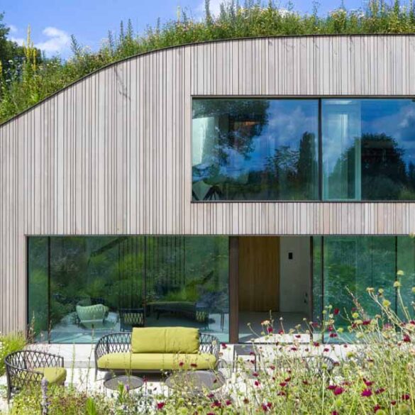 a-house-built-into-the-ground-and-covered-in-flowers