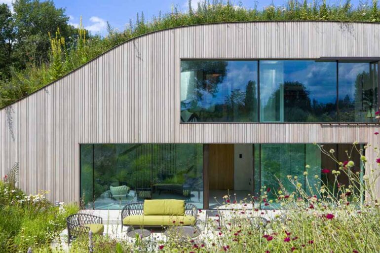 a-house-built-into-the-ground-and-covered-in-flowers