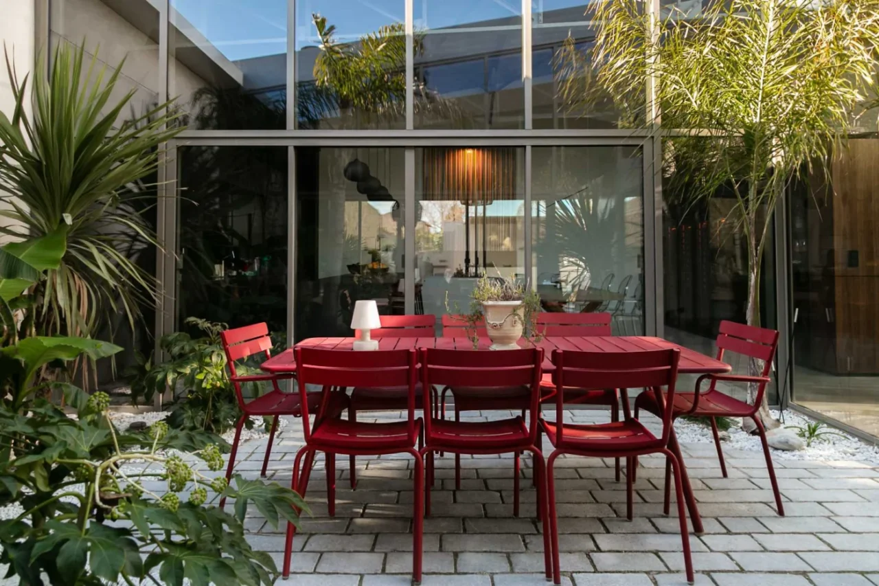 Patio with red outdoor furniture beside the living room of the warehouse home