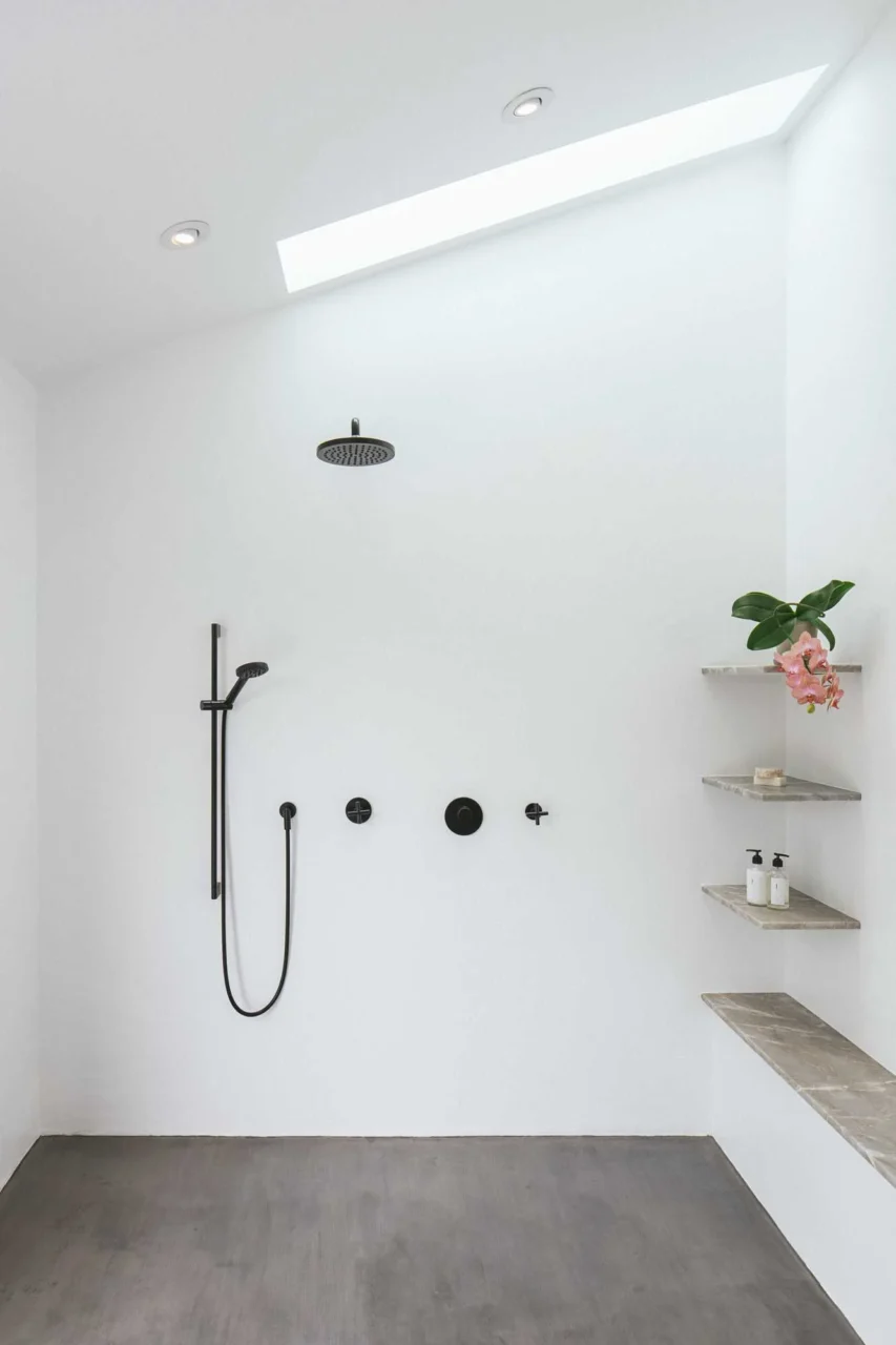 Open shower with shelving and a skylight in the primary suite