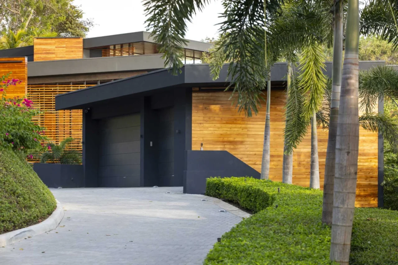 Glazed volumes of the Costa Rica home surrounded by tropical vegetation