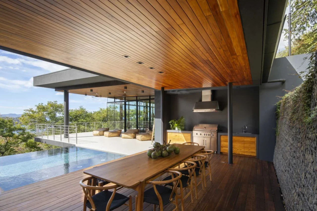 Covered outdoor dining area with an outdoor kitchen by the pool