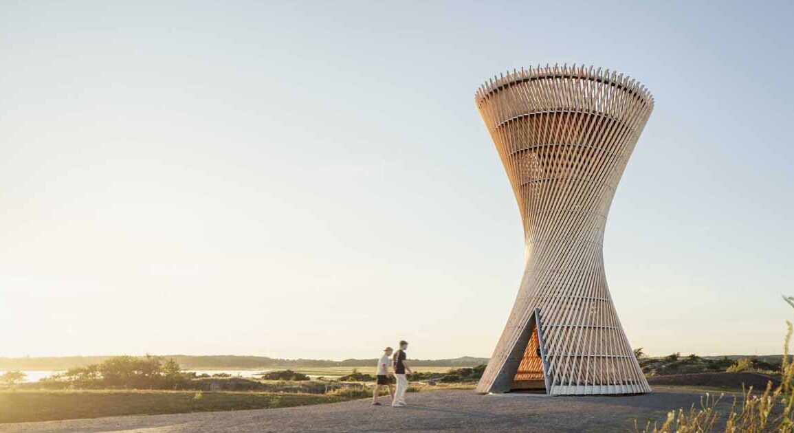 an-observation-tower-that-looks-like-twisted-wood-rises-above-the-swedish-landscape