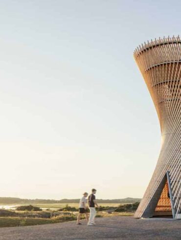 an-observation-tower-that-looks-like-twisted-wood-rises-above-the-swedish-landscape