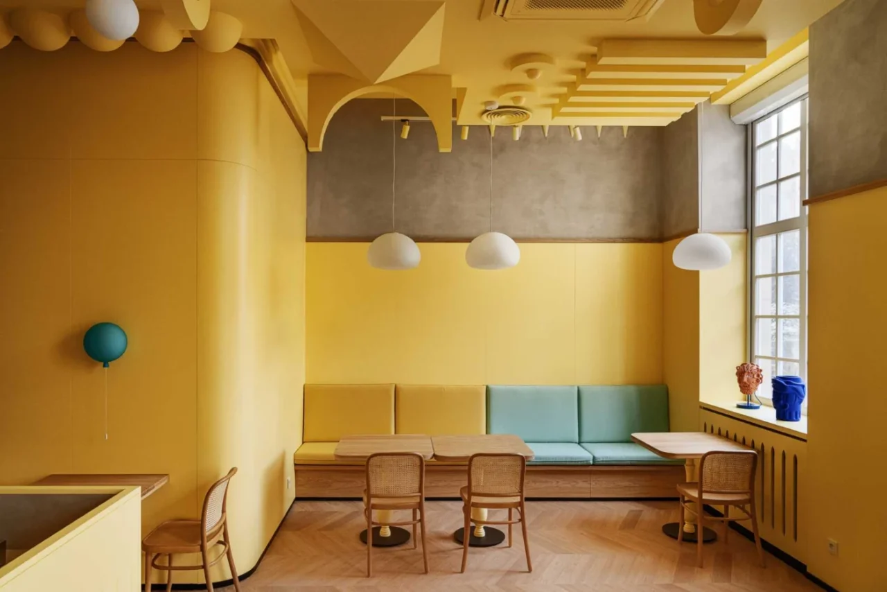 Dessert cafe in Poland with a bright yellow interior and a sculptural ceiling