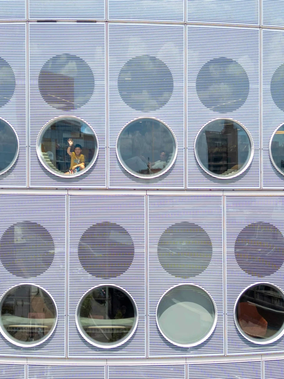 Close view of the porthole facade with lounges set against the windows
