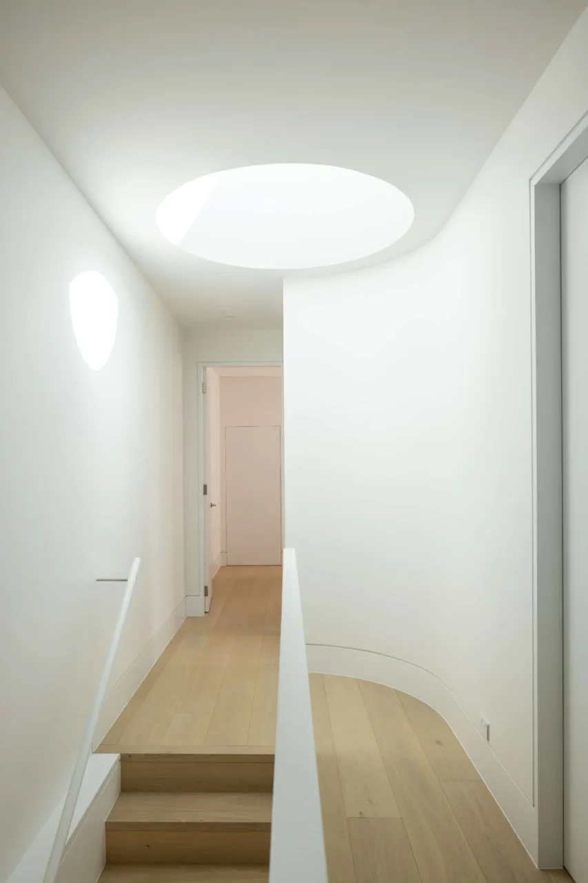 Circular oculus skylight above the stair void of the renovated home
