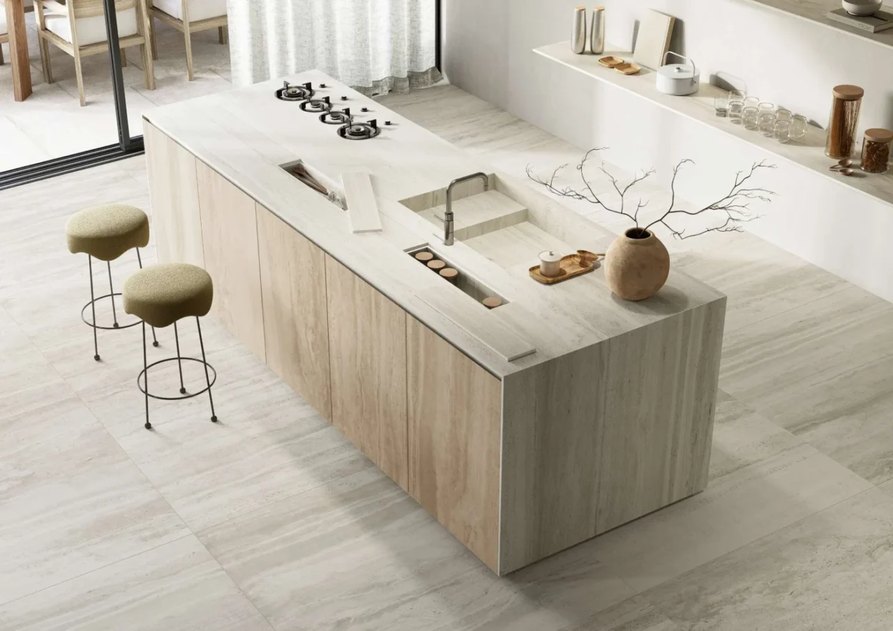Kitchen island wrapped in travertine-look tile in a neutral palette