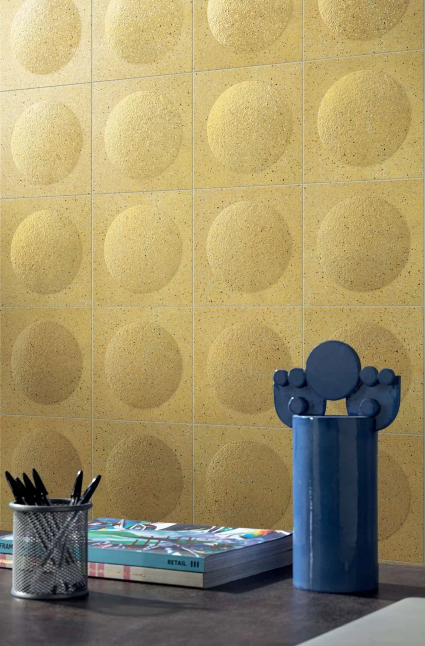 Yellow tiles with rounded bubble shapes covering a wall, an example of colour drenching