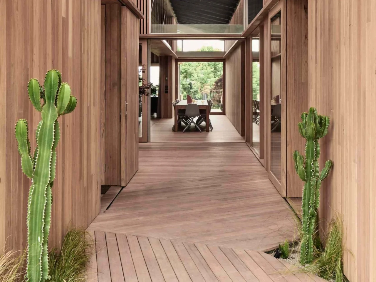 Single-storey coastal house by FIGR. Architecture & Design with timber cladding and a dark angular roof