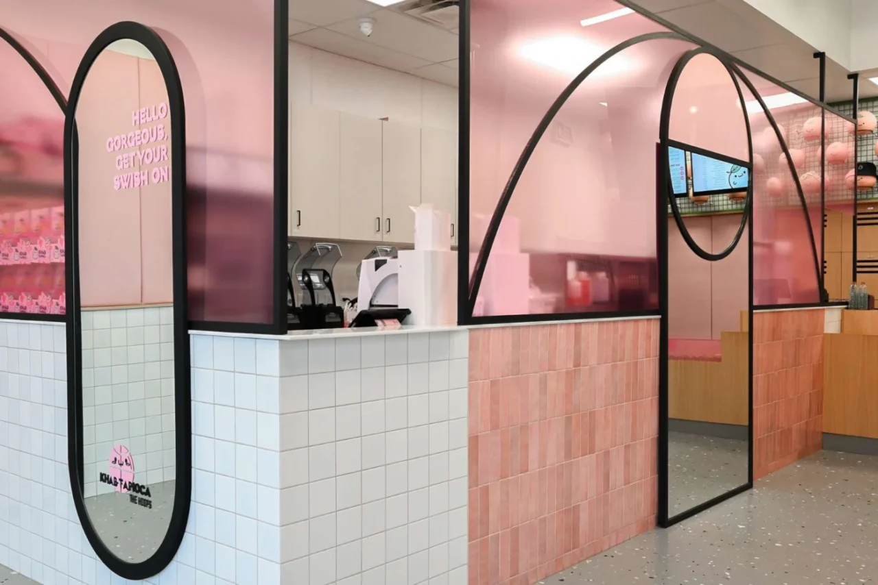 Pink plexiglass wall with curved black lines based on basketball court markings