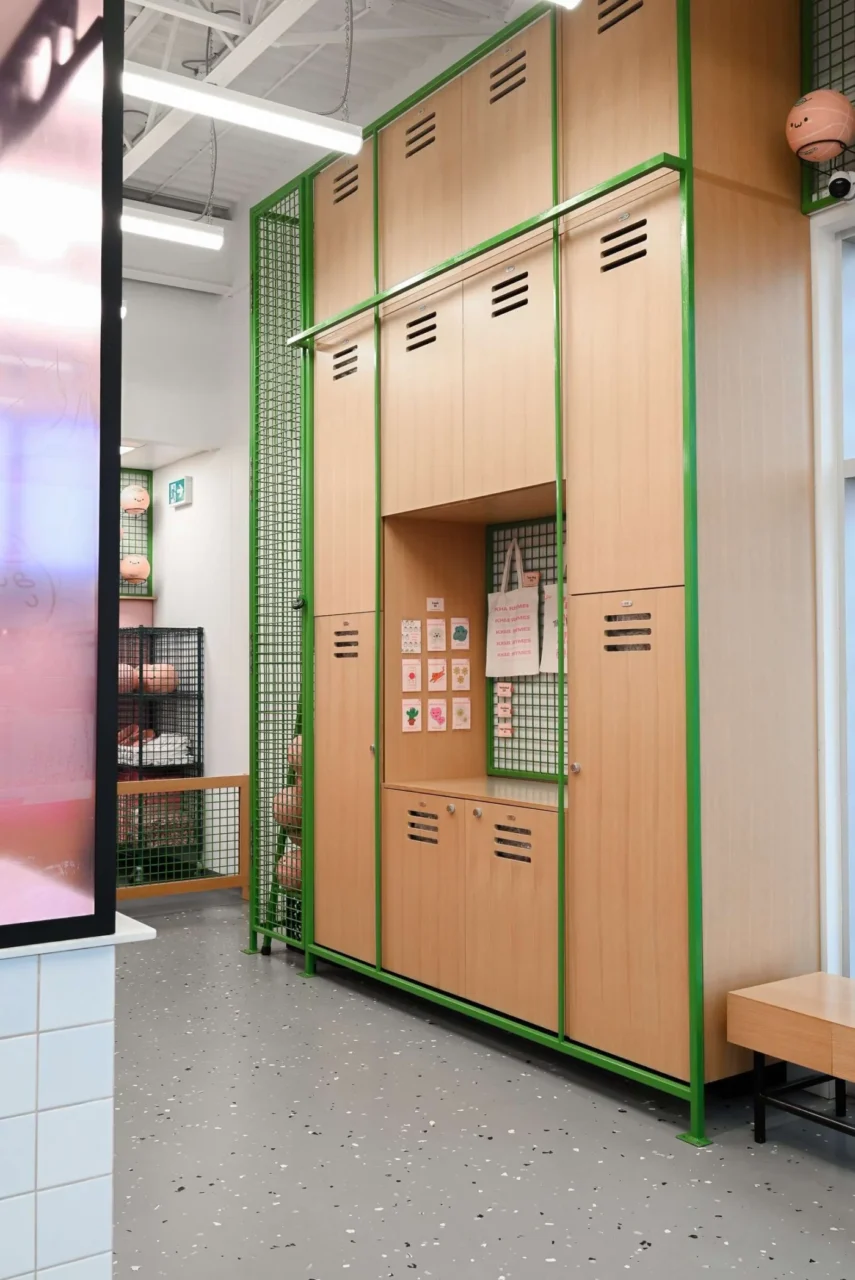 Locker-style wall with numbered green doors displaying merchandise and supplies