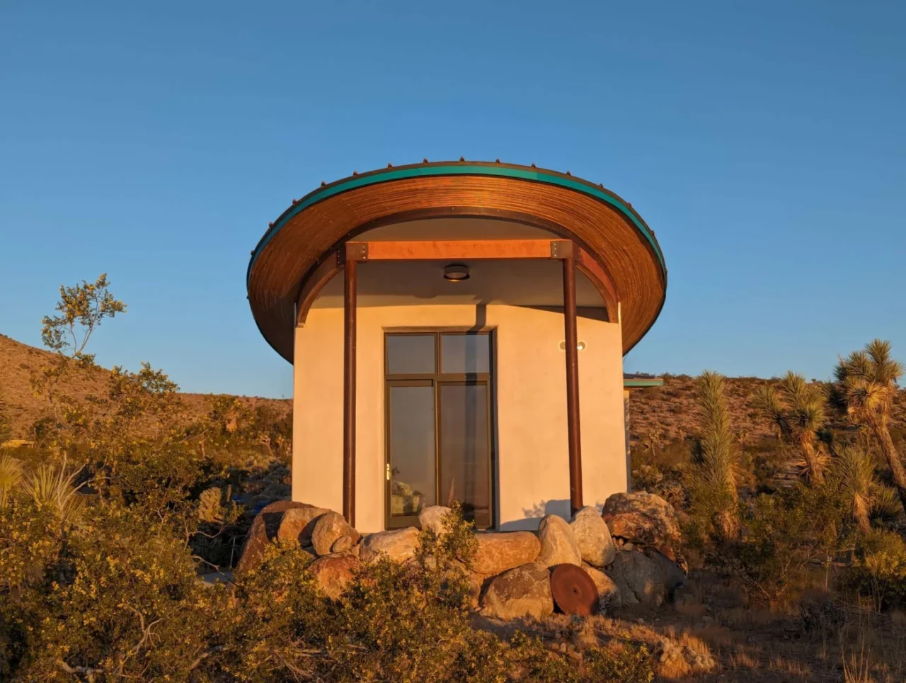 Exterior of the Mesa Sky Disk cabin with its natural lime plaster finish