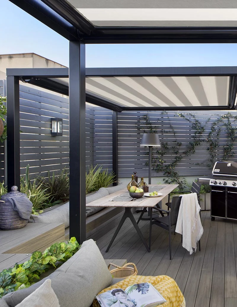 Terrace dining area with a long table, chairs and a built-in banquette by Egue y Seta