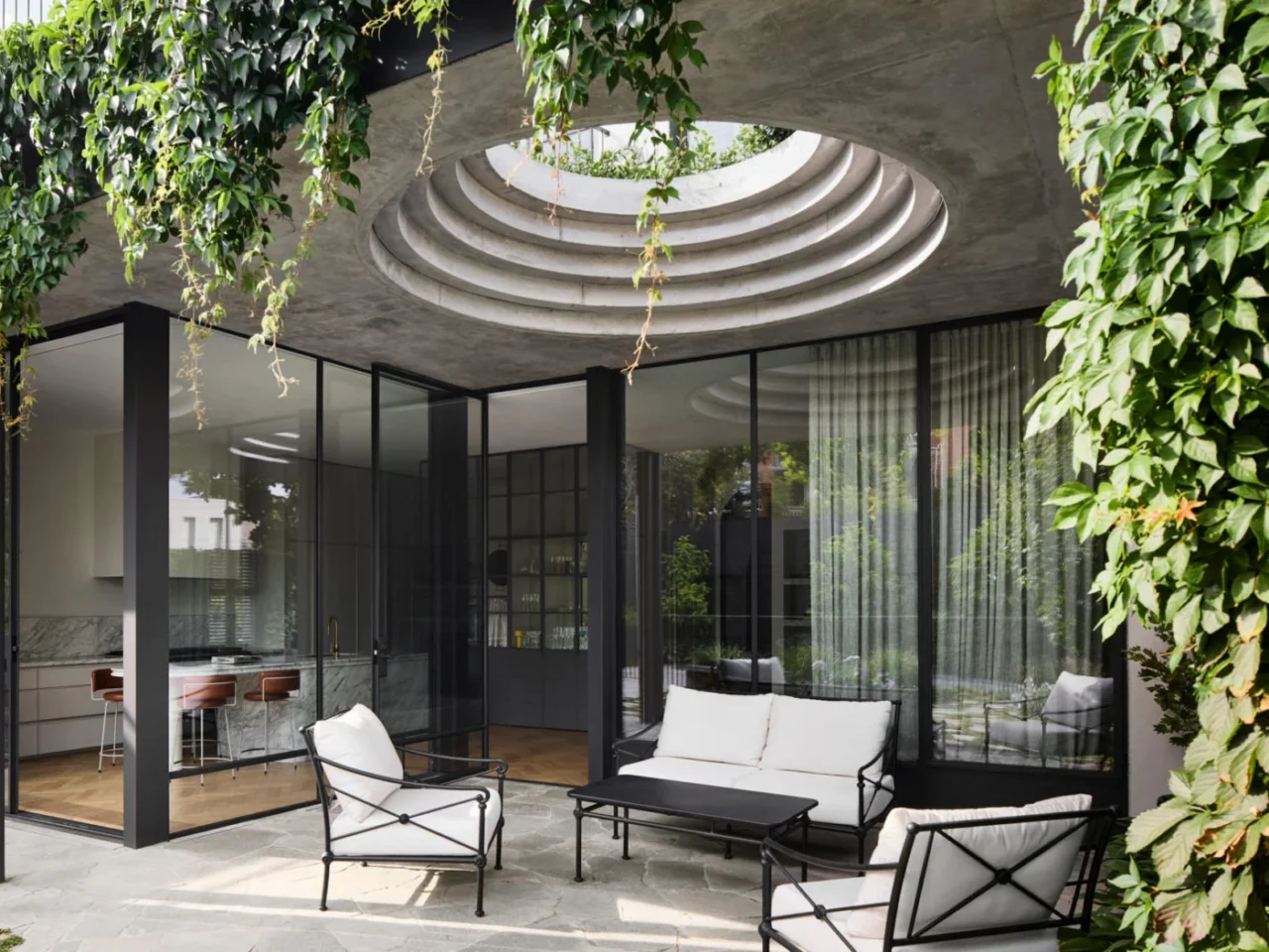 Rear courtyard of an Armadale home with a large circular cut-out in the roof above the outdoor dining area