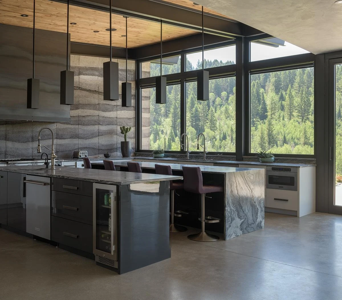 Open-plan kitchen with two islands and rammed earth walls