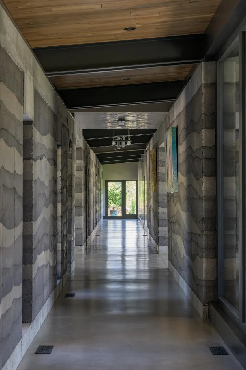 Hallway to the bedrooms lined with striated rammed earth walls