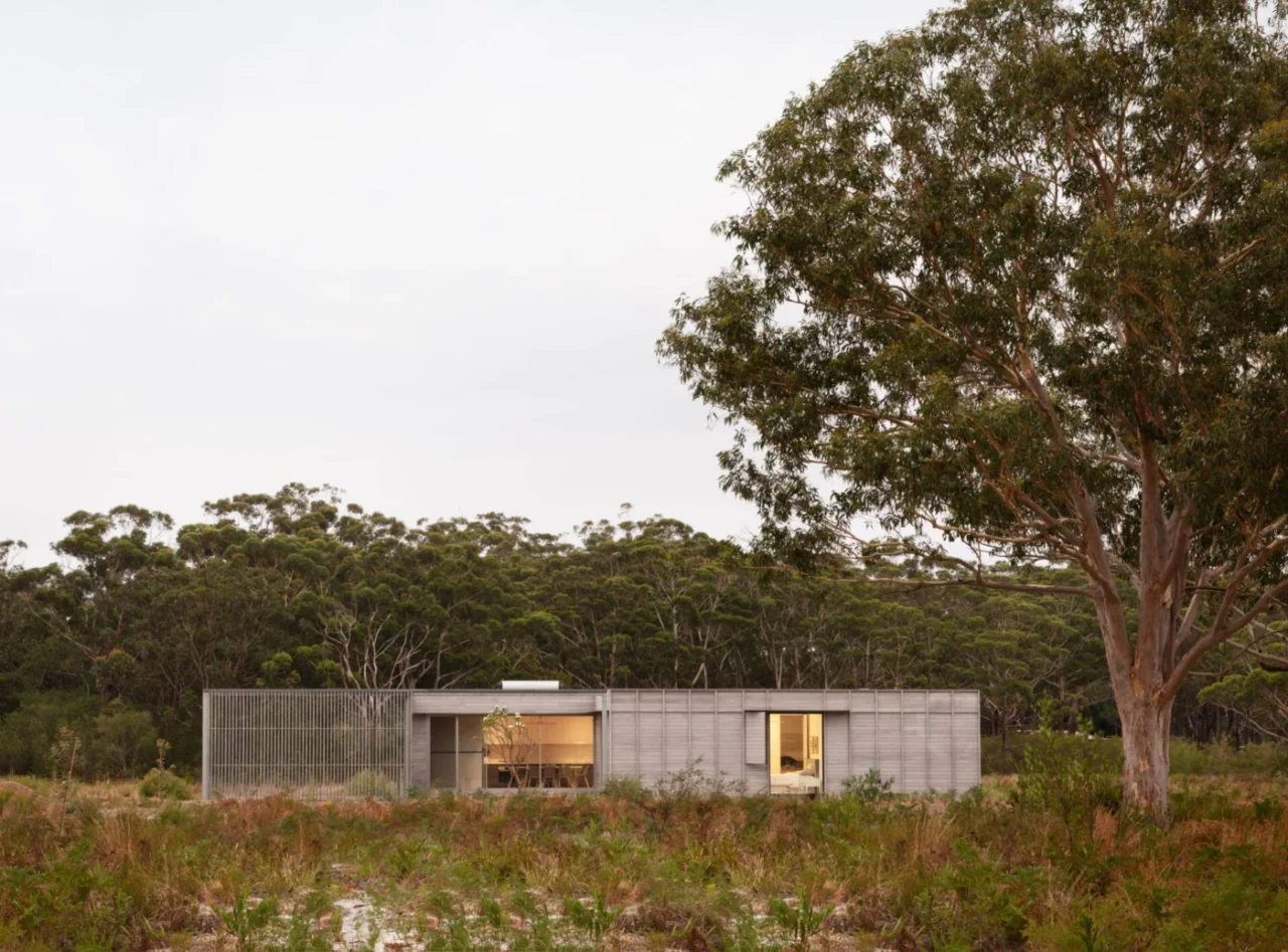 Pale timber-clad prefab home with a generous verandah in the sandy landscape of Mungo Brush