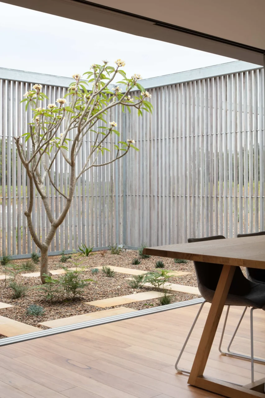 Courtyard of the prefab home with sandstone pavers, pebble beds and hardy planting