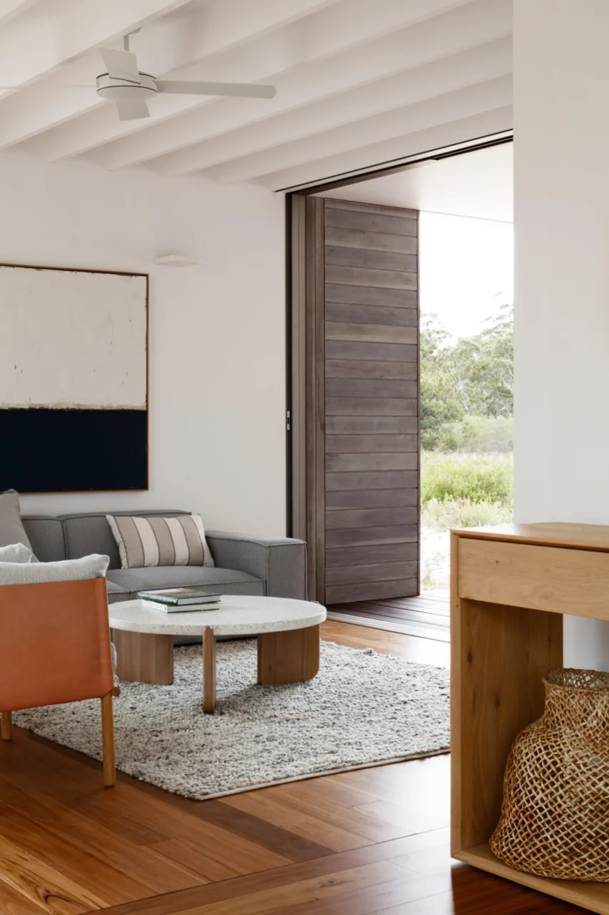 Living room of Courtyard House with warm timber flooring and a natural palette