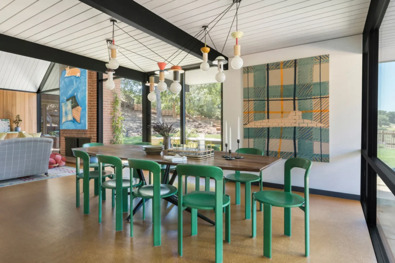 Dining area with cork flooring, natural stone and green chairs