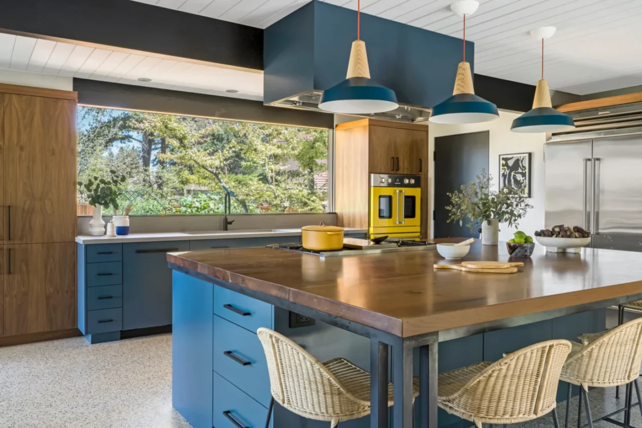 Kitchen with deep blue cabinetry and a black walnut island on steel legs
