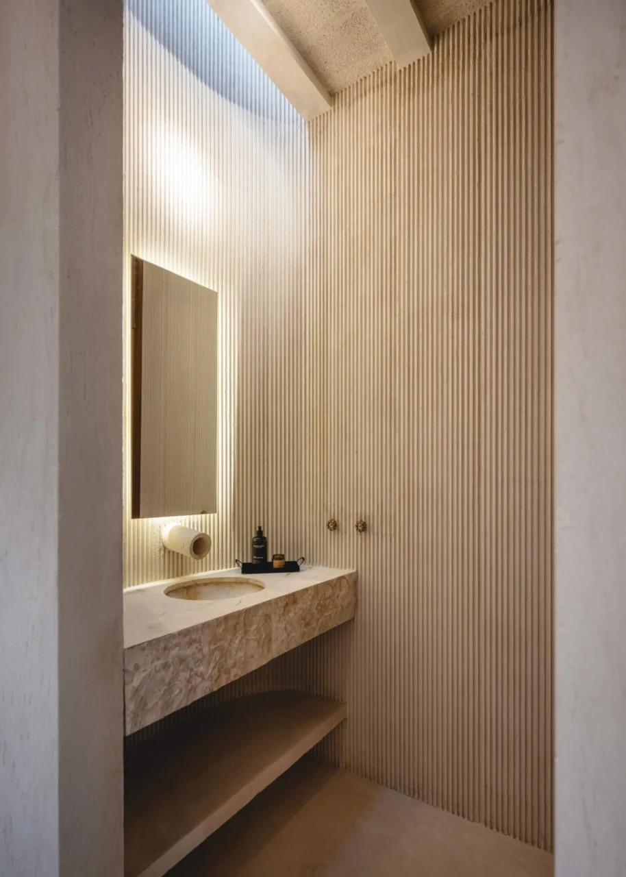 Bathroom with lime-plastered walls and a crescent-shaped skylight