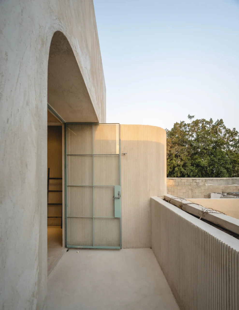 Sky-blue steel-framed glass door opening onto a patio