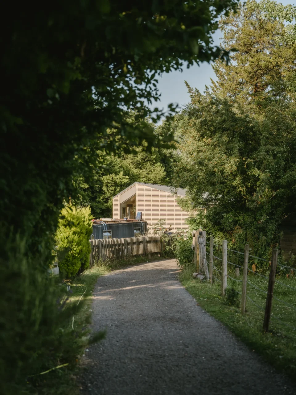 The floating house clad in timber, moored on the canal